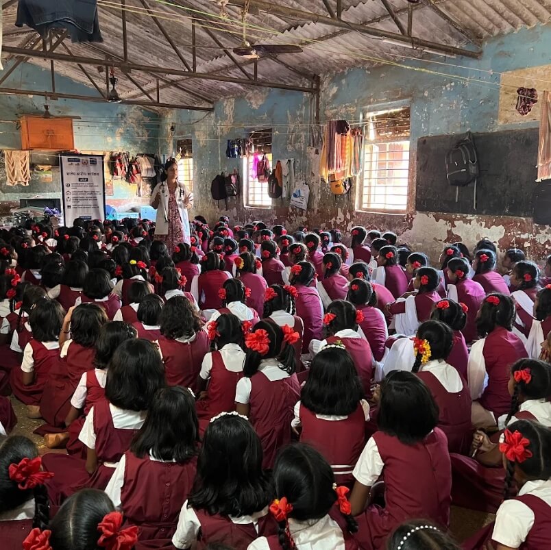 A Child Help Foundation health awareness session in a school, where a health expert speaks to a classroom full of girls. 